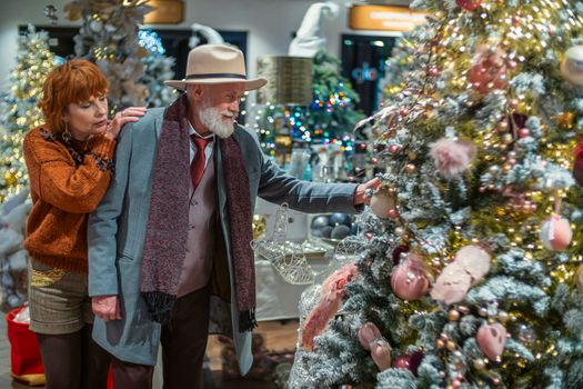 couple aged chooses New Year's decor in the store