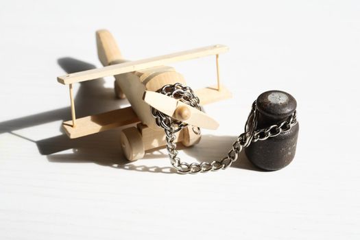 Flight ban concept. Small wooden airplane attached with metal chain