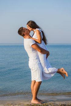 couple in white clothes kissing on the background of the sea