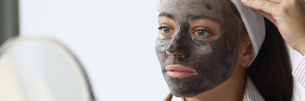 Portrait of young woman wearing clay mask for face, moisturizing effect for skin, morning routine, beauty treatment in morning. Wellness, skincare, care, self love concept