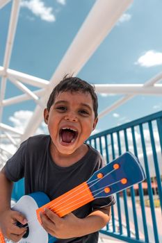 Latin boy playing the ukulele and dreaming of being a rock star in Managua Nicaragua