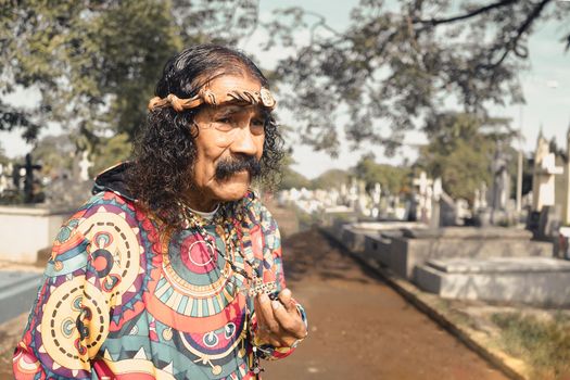 Devotee of Santa Muerte playing her skull and crossbones crucifix in a cemetery in Managua Nicaragua