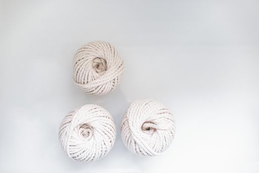 bobbins of light beige pastel color together for weaving macrame needlework on a light background