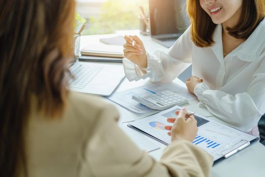 Negotiation, Analysis, Discussion, Asian woman economist and marketer pointing to a financial data sheet to plan investments to prevent risks and losses for the company.