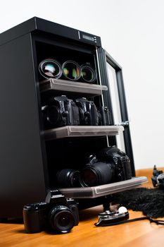 electronic dehumidify dry cabinet for storage cameras lens and other photography equipment. Shallow depth of field, closeup at equipment inside the cabinet.