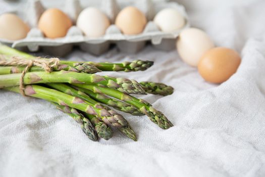 Asparagus and eggs on a fabric linen background. The concept of a healthy and healthy breakfast. Place for an inscription