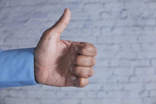 man's hand hand showing a thumb-up on white background .