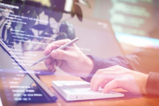 Businessman working with laptop computer on wooden desk in modern office . Programmers and cyber security technologies design.