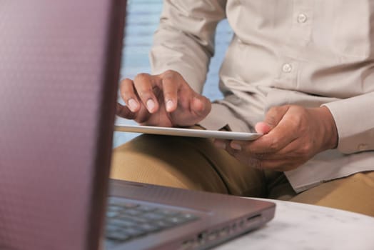 man's hand working on digital tablet at office desk