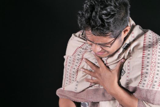 Mature man coughing isolated on black background .