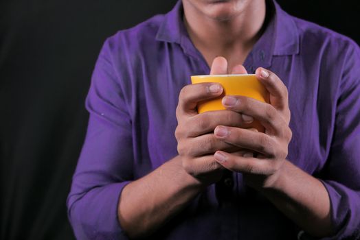 close up of man hand holding mug isolated on black