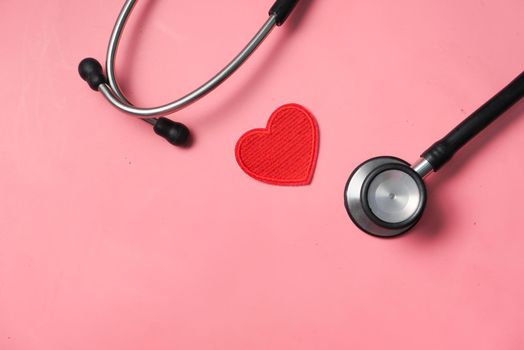 heart shape symbol and stethoscope on pink background .