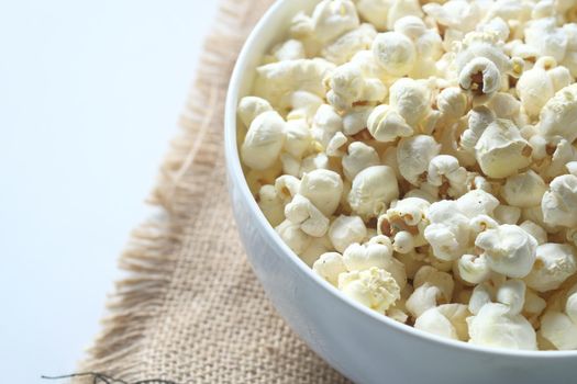 popcorn in a bowl on wooden des.