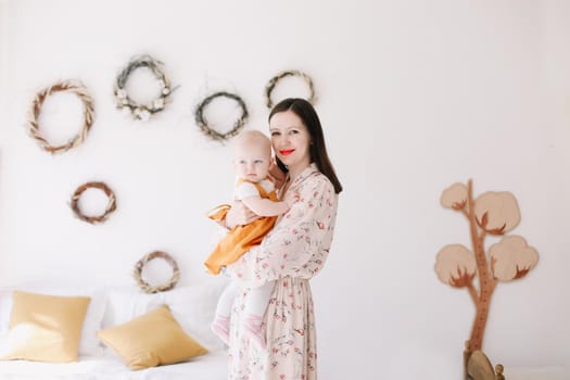 Photo of a happy mom holding and hugging little daughter, loving family sincere feelings.