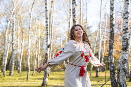 Indigenous people. beautiful woman in national ukrainian national traditional costume clothes dancing in forest