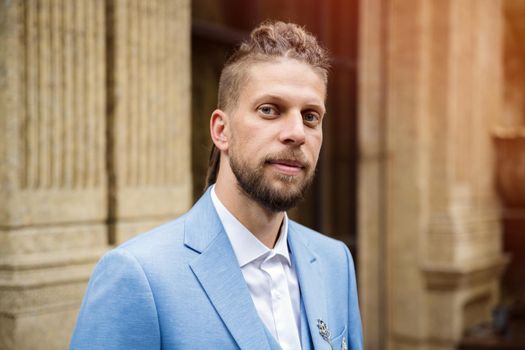 Caucasian man in blue three piece suit, outdoor portrait.