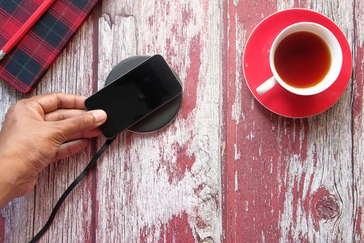 charging Smartphone Using Wireless Charging Pad, close up