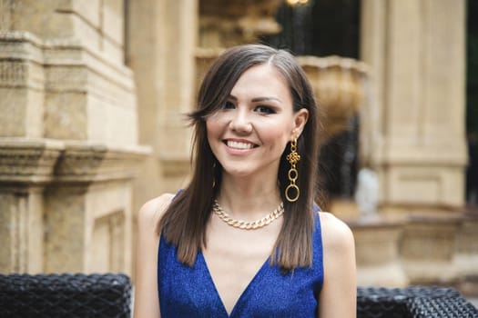 Multiracial pretty smiling woman in blue dress outdoor portrait.