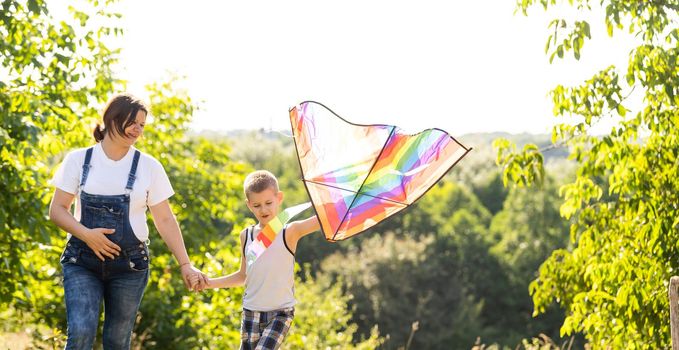 pregnant woman with her son playing a kite