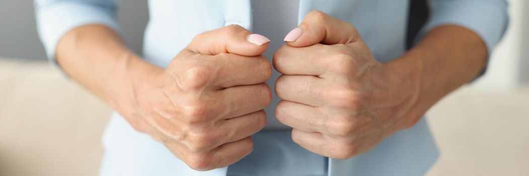 Close-up of woman fixing blue jacket, touching blazer to feel more confident. Successful female posing in trendy outfit in room. Modeling, boss, businesswoman concept