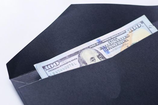 100 dollar cash in a envelope on a desk .