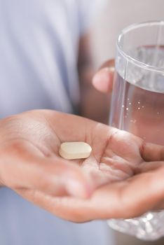 unrecognized man in white shirt taking medicine .