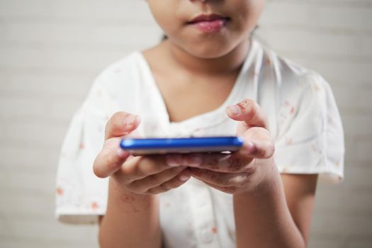 side view of child hand holding a smart phone indoor ,