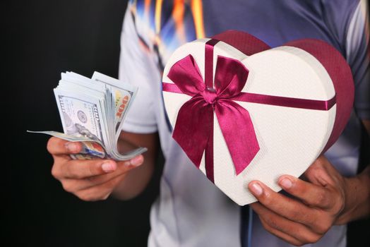 young man hand holding gift box and cash
