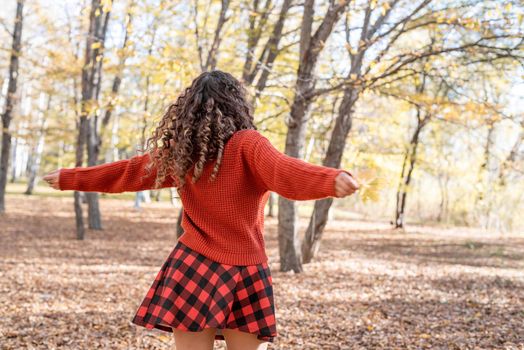 Autumn nature. young happy woman in red sweater and skirt walking in autumn forest