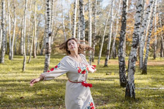 Indigenous people. beautiful woman in national ukrainian national traditional costume clothes dancing in forest