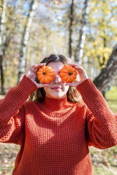 Leisure, free time. Beautiful caucasian woman in red sweater on a picnic outdoors, sitting on a plaid in autumn forest