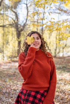 Autumn nature. young happy woman in red sweater and skirt walking in autumn forest