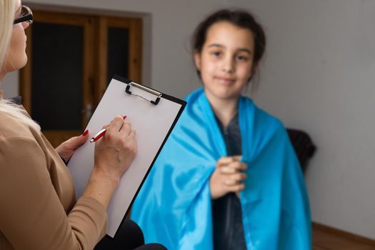 psychologist and little girl with ukraine flag.