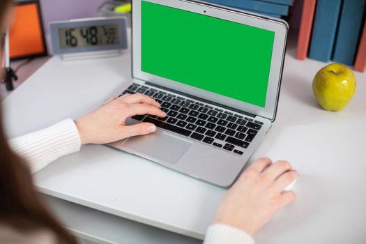 A green box on a laptop screen. The teen's left hand operates the laptop's calvaria and the right hand moves the mouse. Simultaneous keyboard and mouse operation by one person.