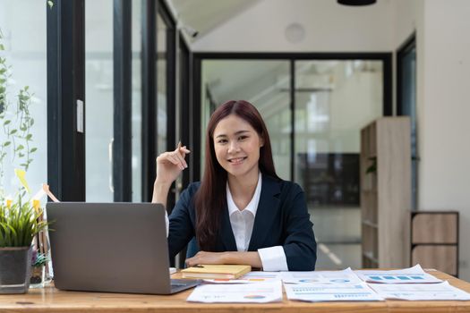 Portrait of smiling beautiful business asian woman with working in modern office desk using computer, Business people employee freelance online marketing e-commerce telemarketing concept