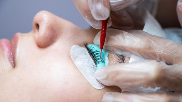 Young woman undergoing eyelash tinting and lamination procedure