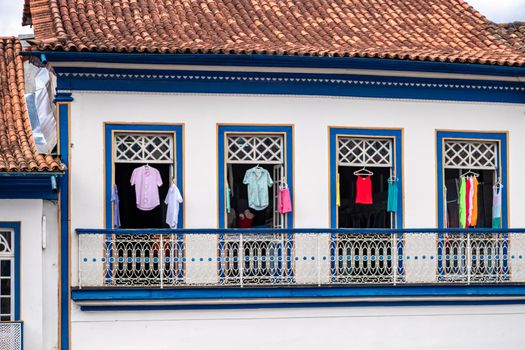 Colorful clothes in the windows of a historic building.