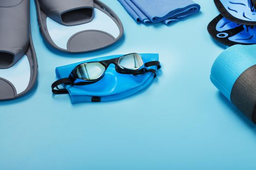 Sports equipment for swimming in the pool and open water on a blue background, close-up