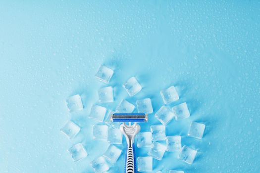 Blue shaving machines in a row on a blue background with ice cubes. The concept of cleanliness and frosty freshness