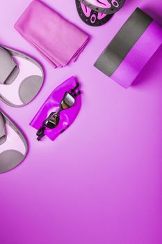 A set for swimming training in open water and in the pool on a pink background