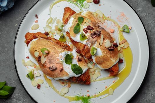 croissant with sweet cream and almonds on a plate. Delicious and healthy breakfast.