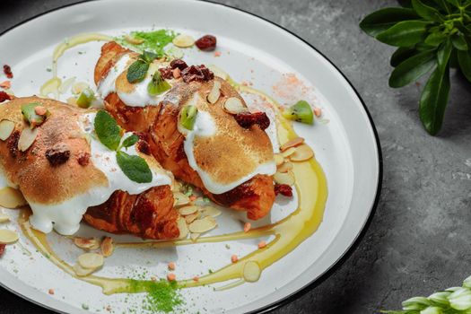 croissant with sweet cream and almonds on a plate. Delicious and healthy breakfast.