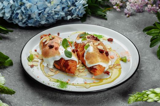 croissant with sweet cream and almonds on a plate. Delicious and healthy breakfast.