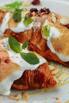 croissant with sweet cream and almonds on a plate. Delicious and healthy breakfast.