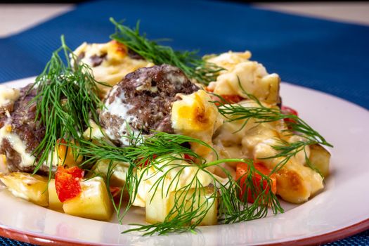 Delicious German meatballs in caper sauce served with boiled potatoes close-up in a plate on the table. Horizontal