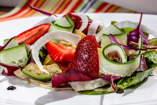 Summer Strawberry, cucumber salad with lettuce, feta cheese and almonds. Healthy Food.