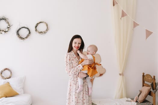 Photo of a happy mom holding and hugging little daughter, loving family sincere feelings.