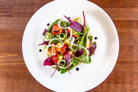 Summer Strawberry, cucumber salad with lettuce, feta cheese and almonds. Healthy Food.