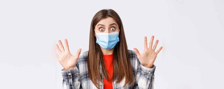 Coronavirus outbreak, leisure on quarantine, social distancing and emotions concept. Excited young attractive woman in medical mask show ten fingers, number or amount, stare impressed.