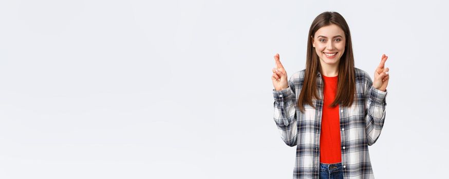 Lifestyle, different emotions, leisure activities concept. Hopeful cute caucasian girl in checked shirt, making wish, cross fingers good luck and smiling optimistic, white background.